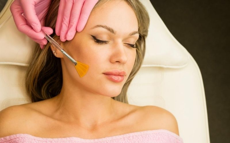 Kỹ thuật viên dùng cọ thoa dưỡng chất mặt